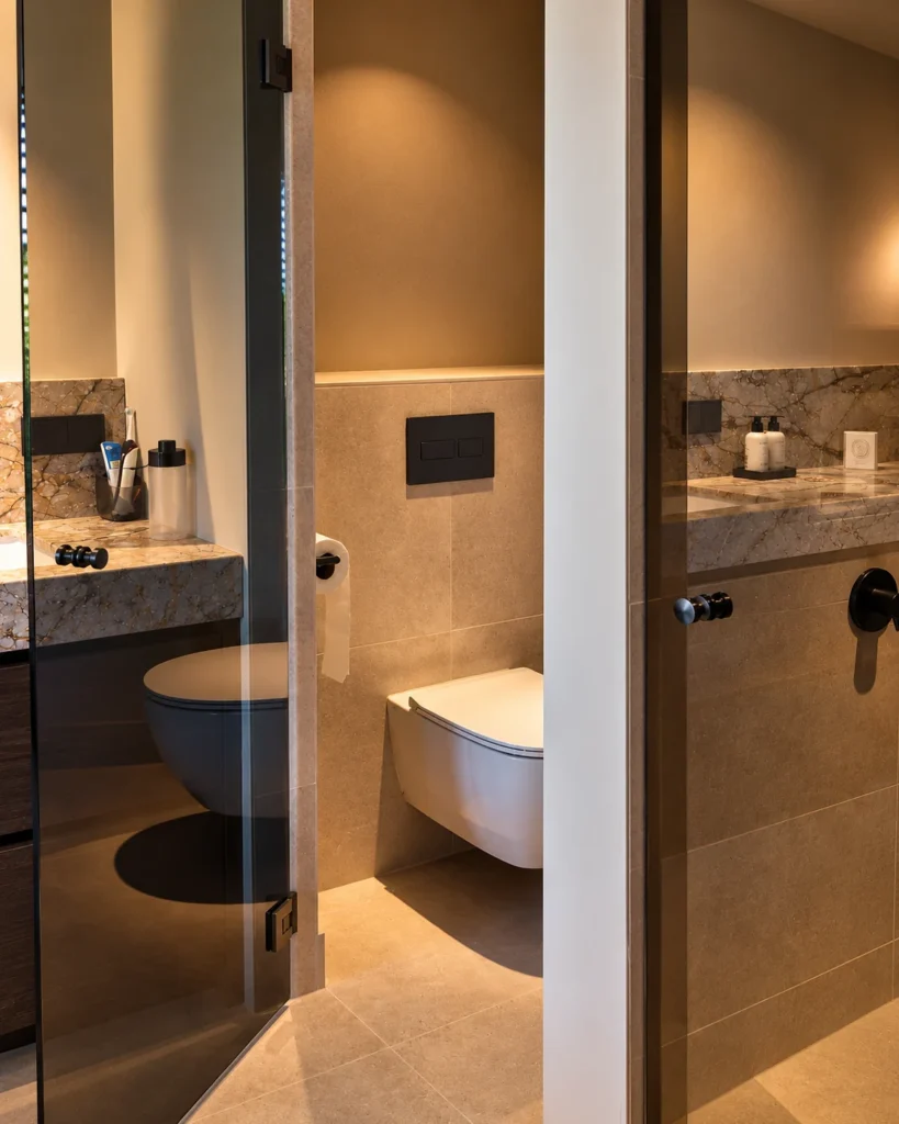 Toiletnis achter rookglas met reflectie van het natuurstenen wastafelblad